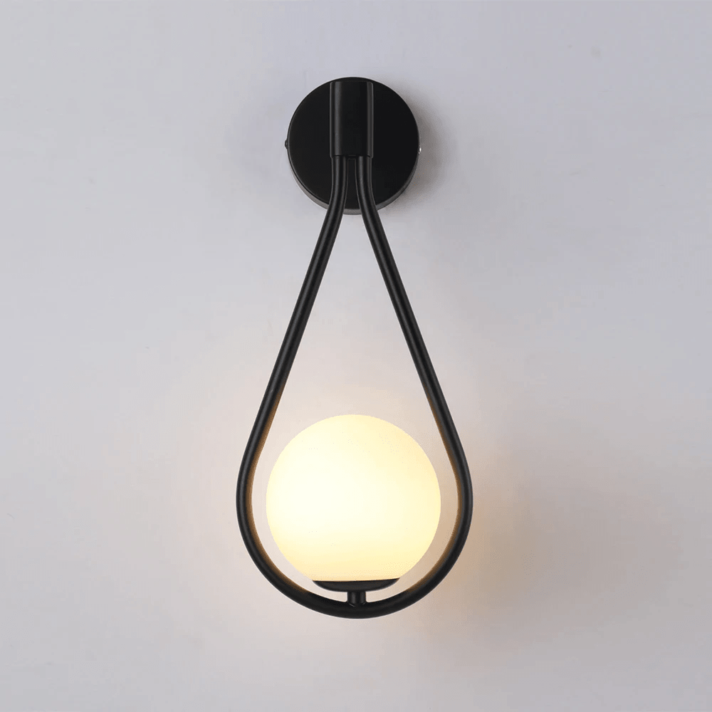 Black teardrop wall sconce switched on, frosted glass globe glowing