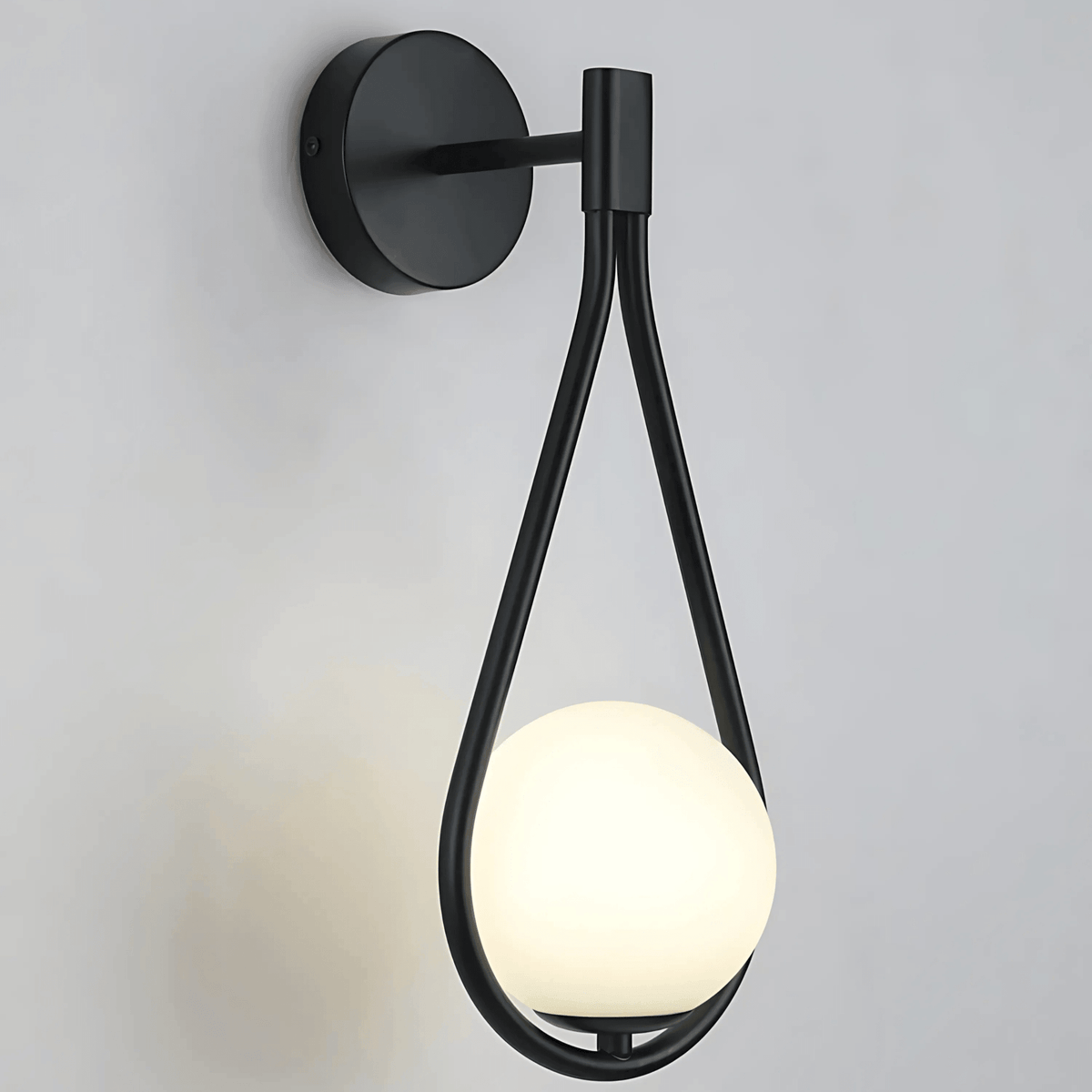 Close view of the black sconce frame holding the frosted glass globe