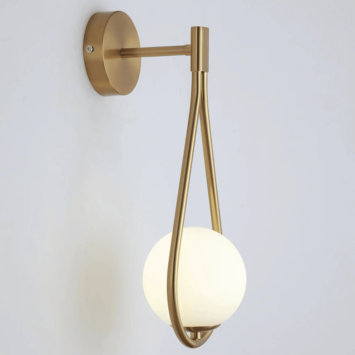 Close view of the brass sconce frame holding the frosted glass globe