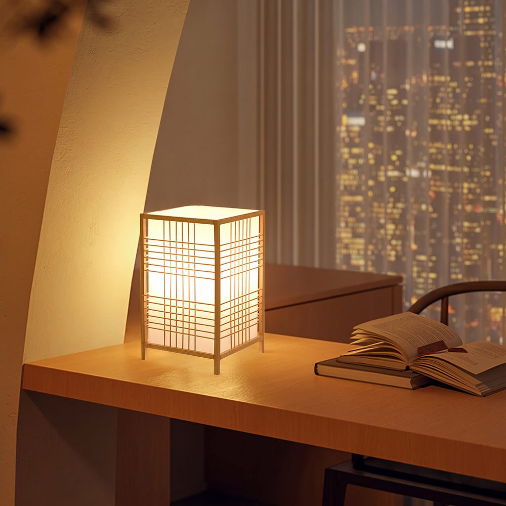 Bamboo grid lantern lamp glowing on a desk beside an open book