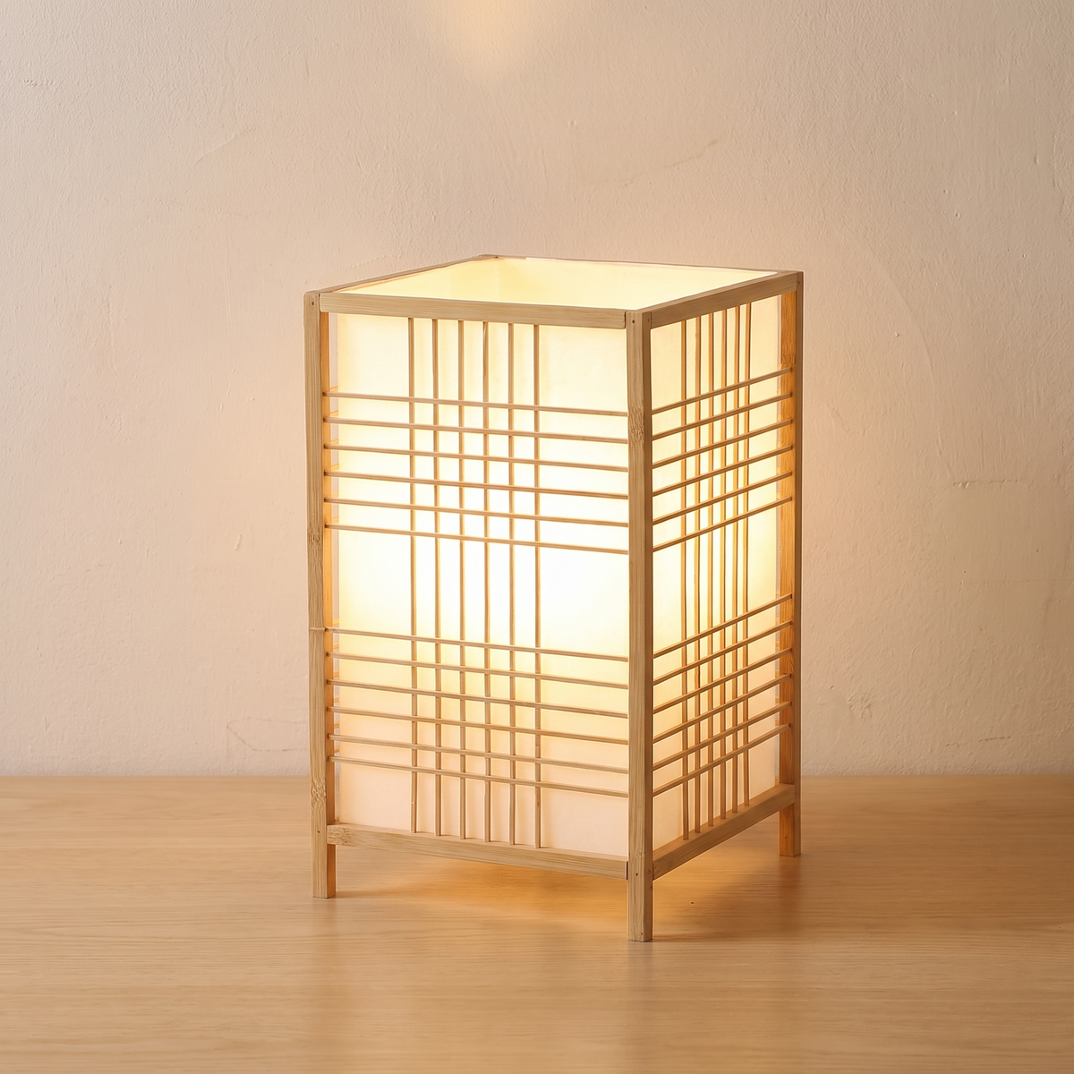 Lit bamboo grid lantern table lamp on a light wooden table
