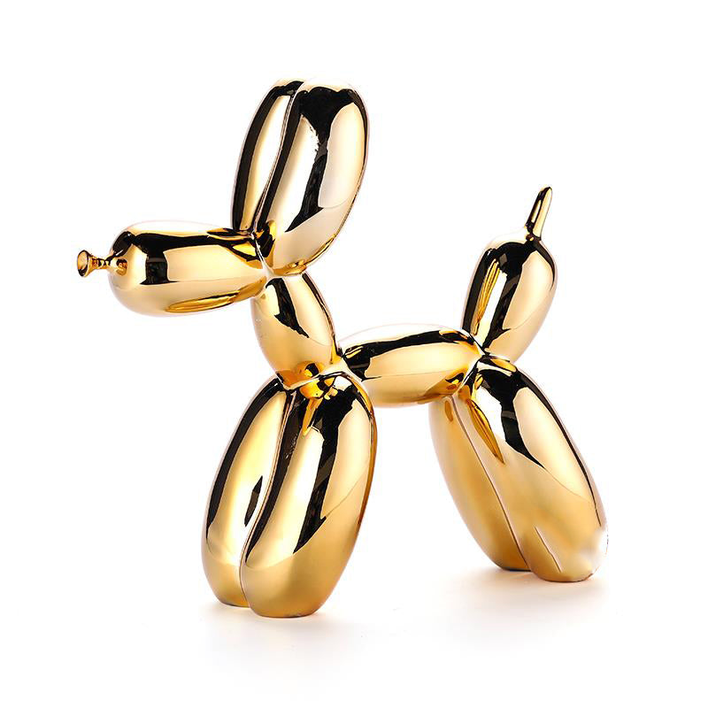 Gold glossy balloon dog sculpture on a white background