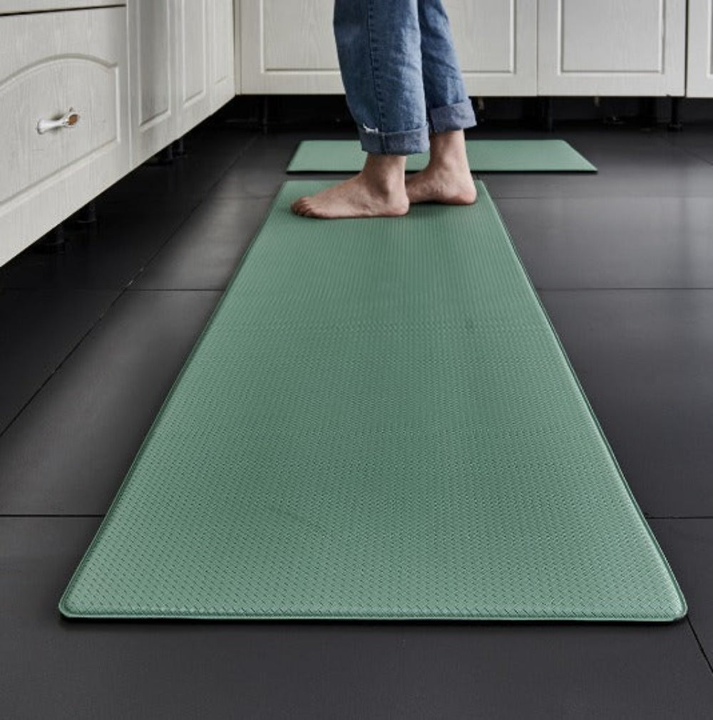 Anti-fatigue kitchen mat in Green on a dark kitchen floor