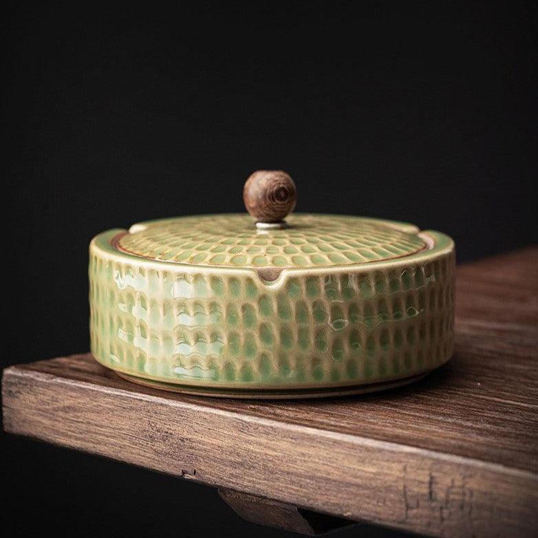 Handmade Japanese ceramic ashtray with wood lid front view on a neutral studio background