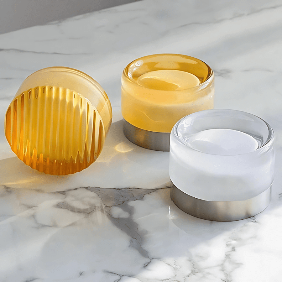 Three Hera glass wall lights resting on a marble surface
