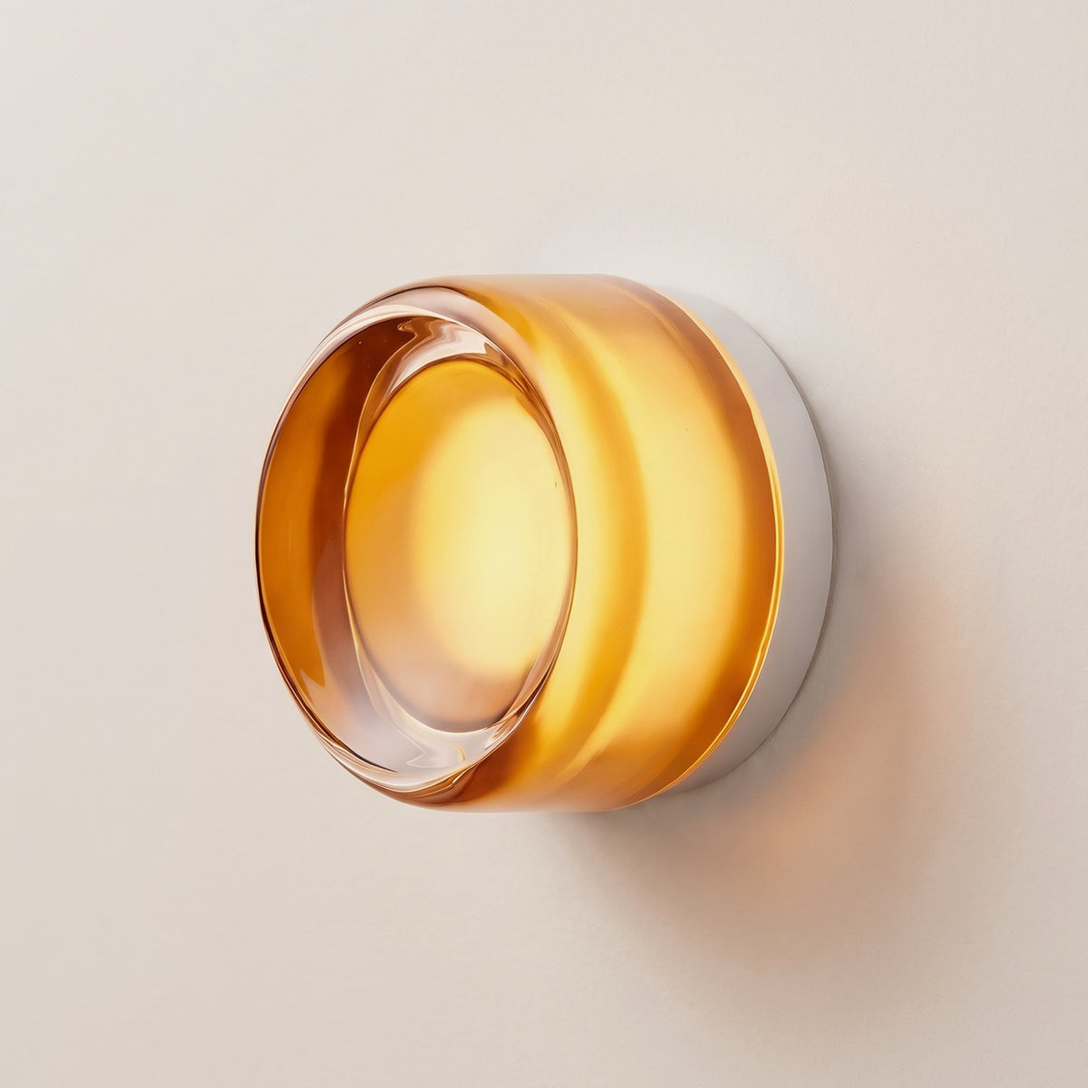 Hera glass wall sconce in Orange, Style B, smooth amber glass on a plaster wall