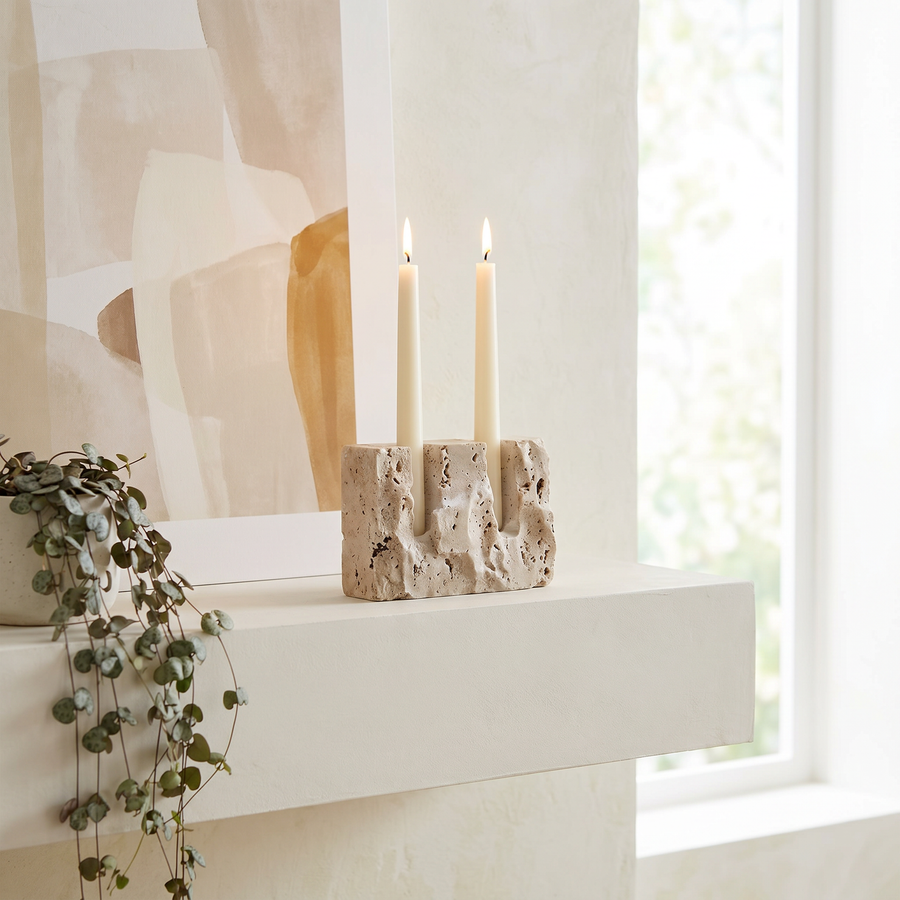 Travertine candle holder in the raw matte finish holding a slim taper candle