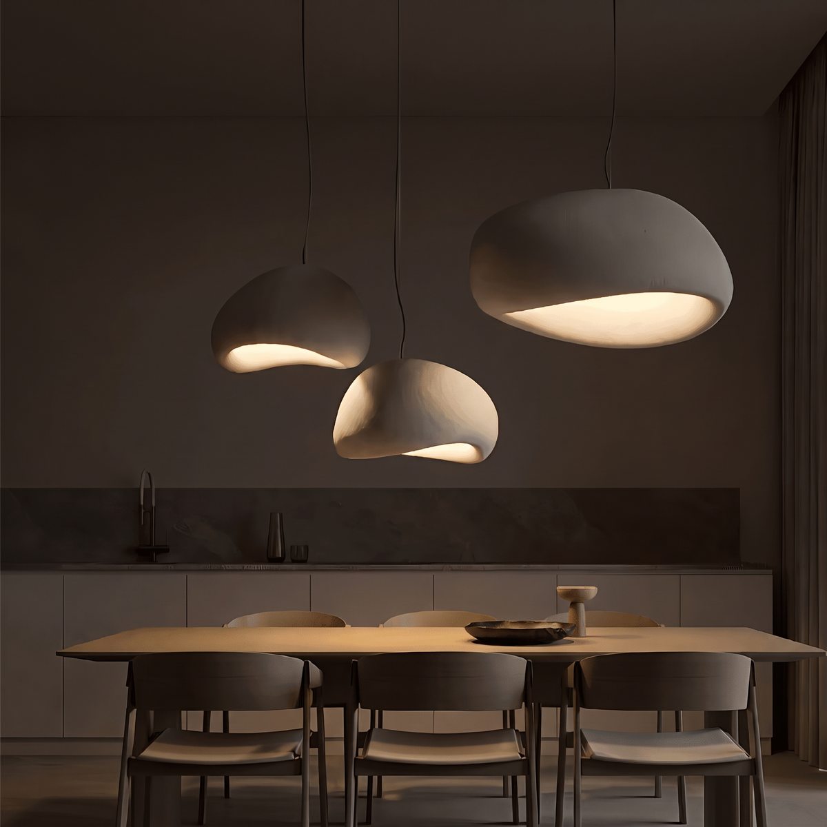 Three Ginza pendant lights glowing over a dining table in the evening