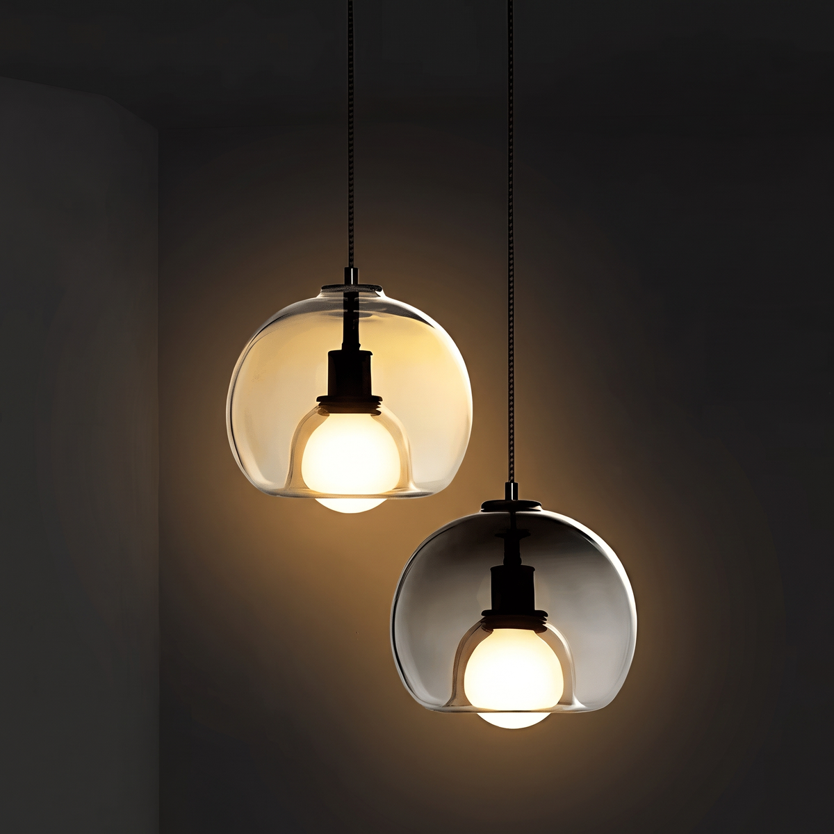 Amber and smoke gray Clyde pendant lights glowing in a dark room