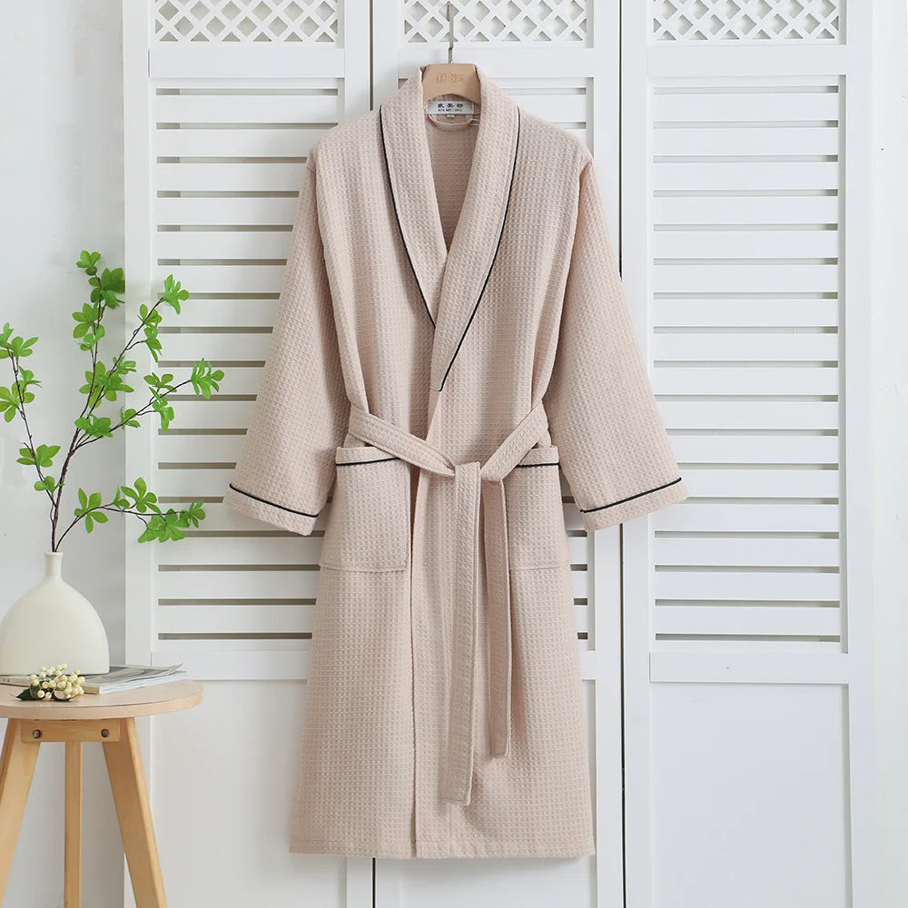 Khaki waffle bathrobe with dark piping hanging on a white shutter