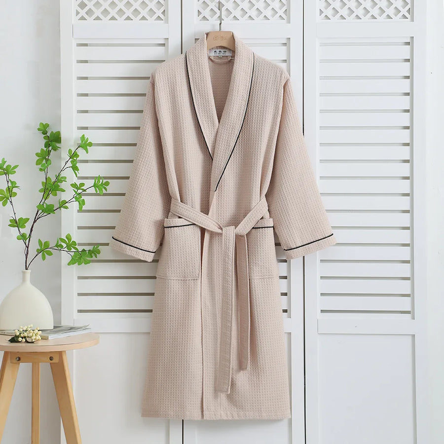 Khaki waffle bathrobe with dark piping hanging on a white shutter