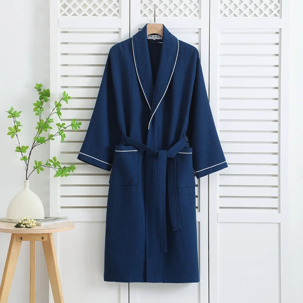 Navy waffle bathrobe with white piping and tie belt on a hanger