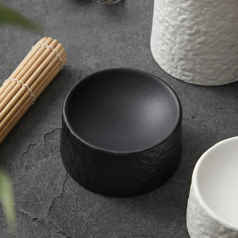 Low black matte pedestal dish showing the stone like texture