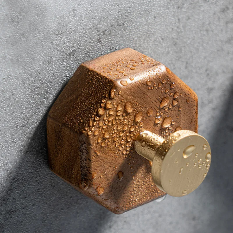 Close up of a walnut hook with water drops on a concrete wall