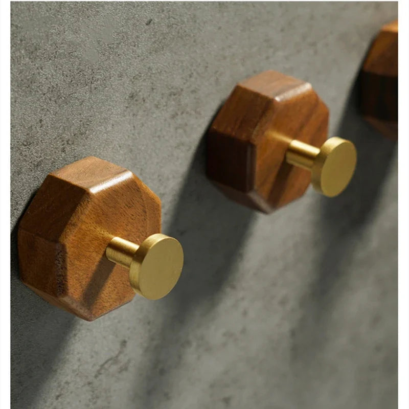Side view of faceted walnut hooks showing grain and round brass peg