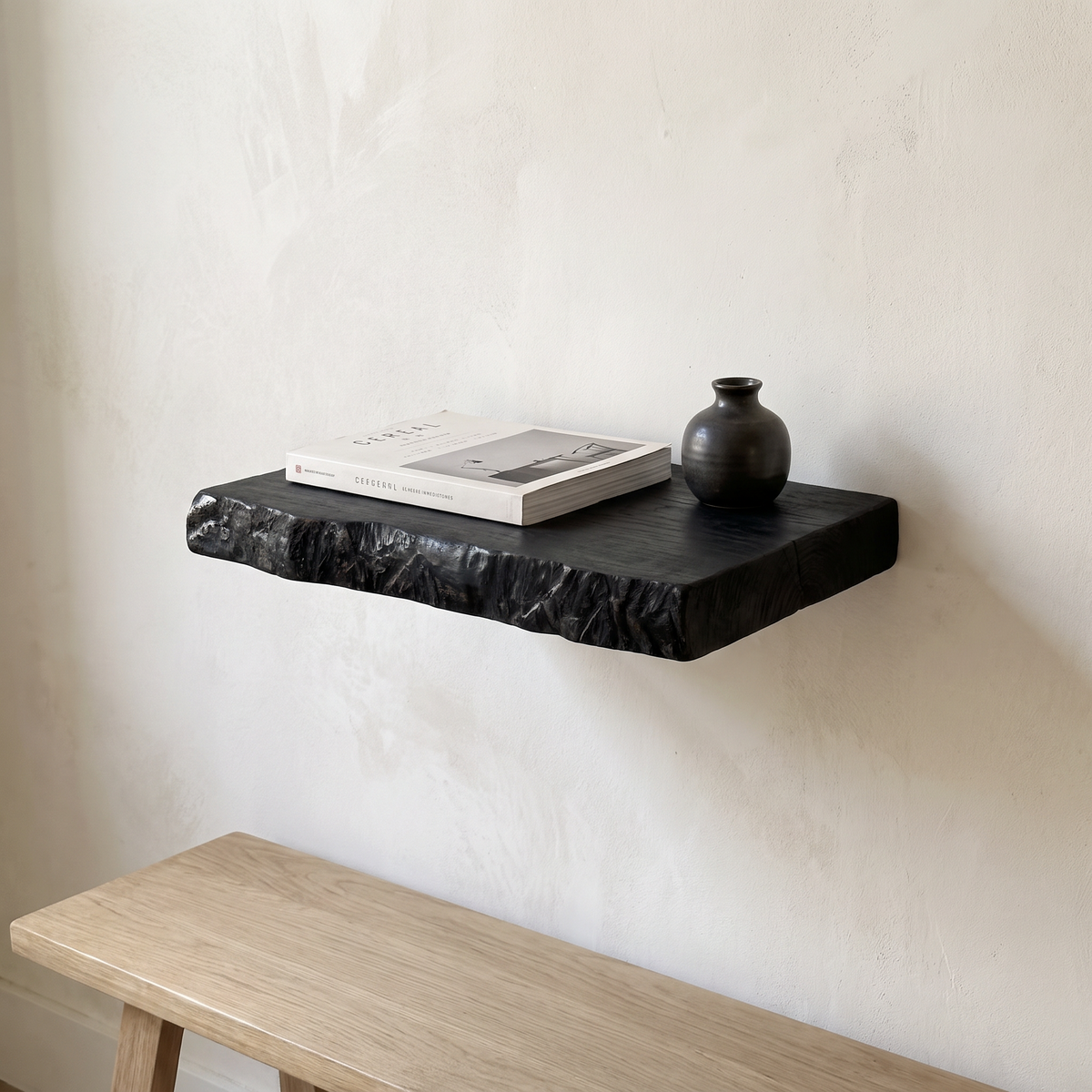 Black live edge floating shelf, 12 inches wide, above an entryway bench