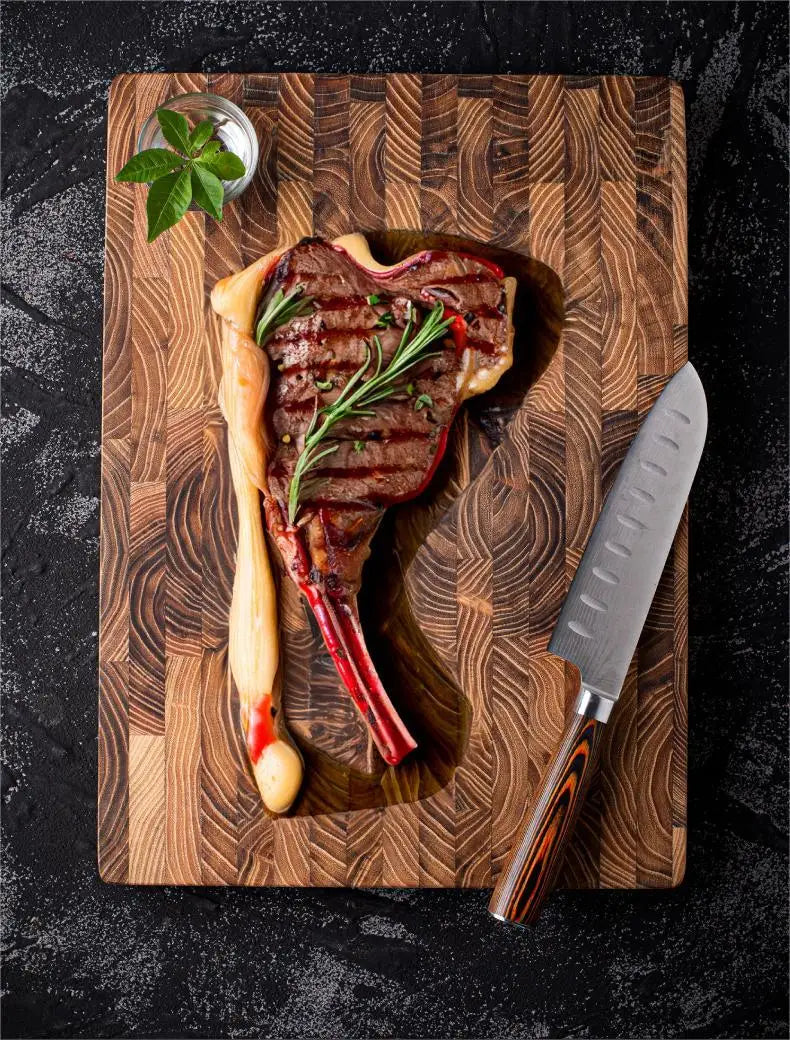 Grilled steak and a knife on a teak end grain cutting board