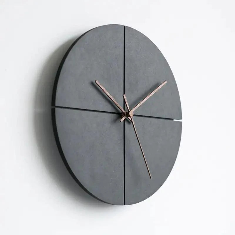 Minimalist black Scandinavian wall clock with numberless dial mounted on a plain white wall