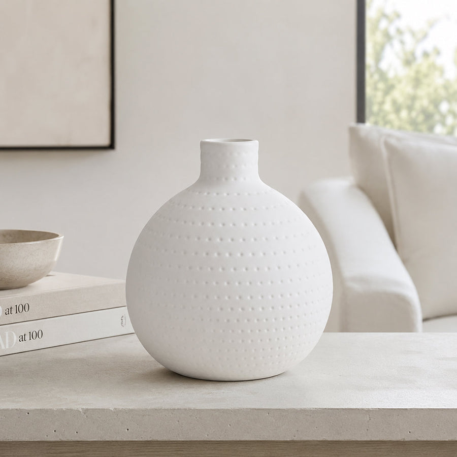 Round dotted ceramic sphere vase in matte white on a coffee table
