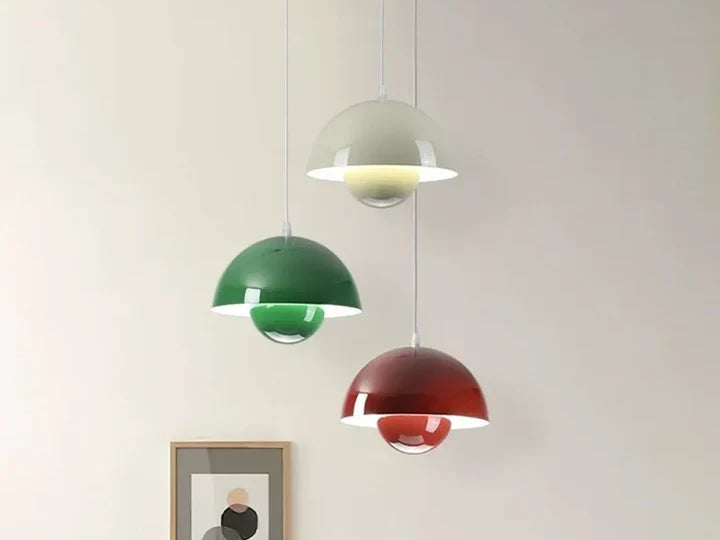 Three mushroom pendant lights in white, green and red hanging at different heights