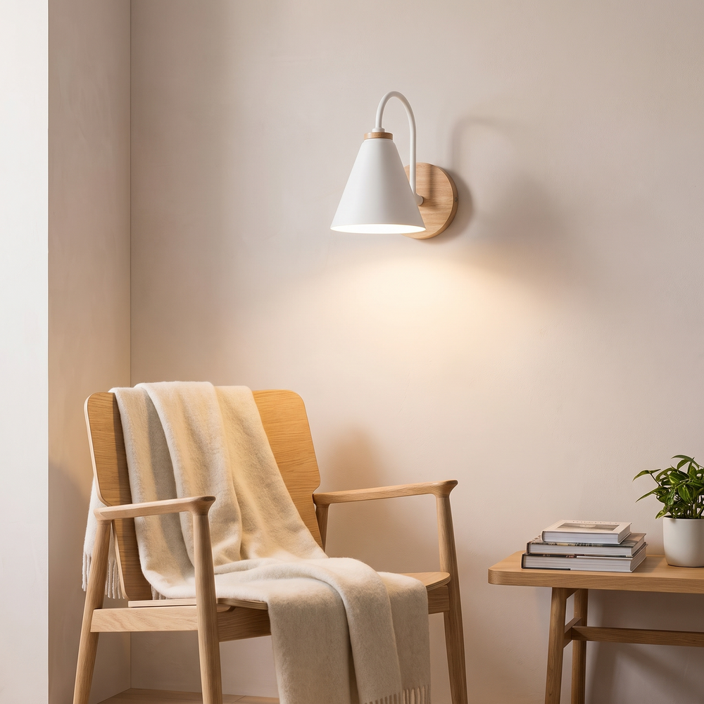 Nordic Iron Wall Sconce in White with wood base above a reading chair