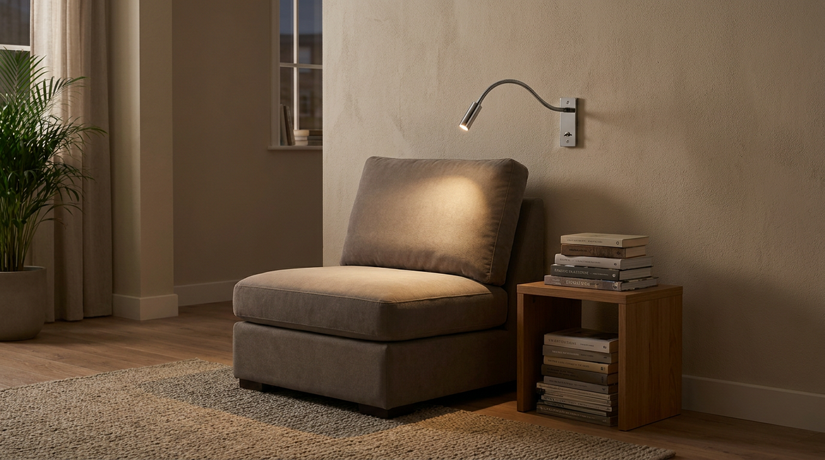 Gooseneck reading wall light beside an armchair in a living room reading corner in the evening