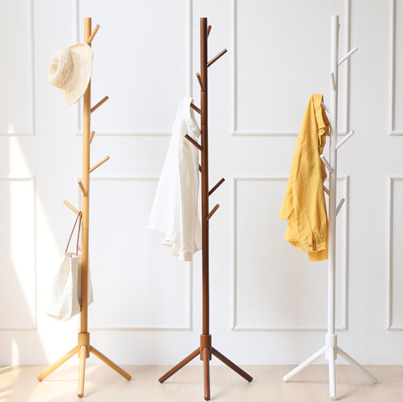 Natural, walnut and white tree coat racks side by side with coats and hats