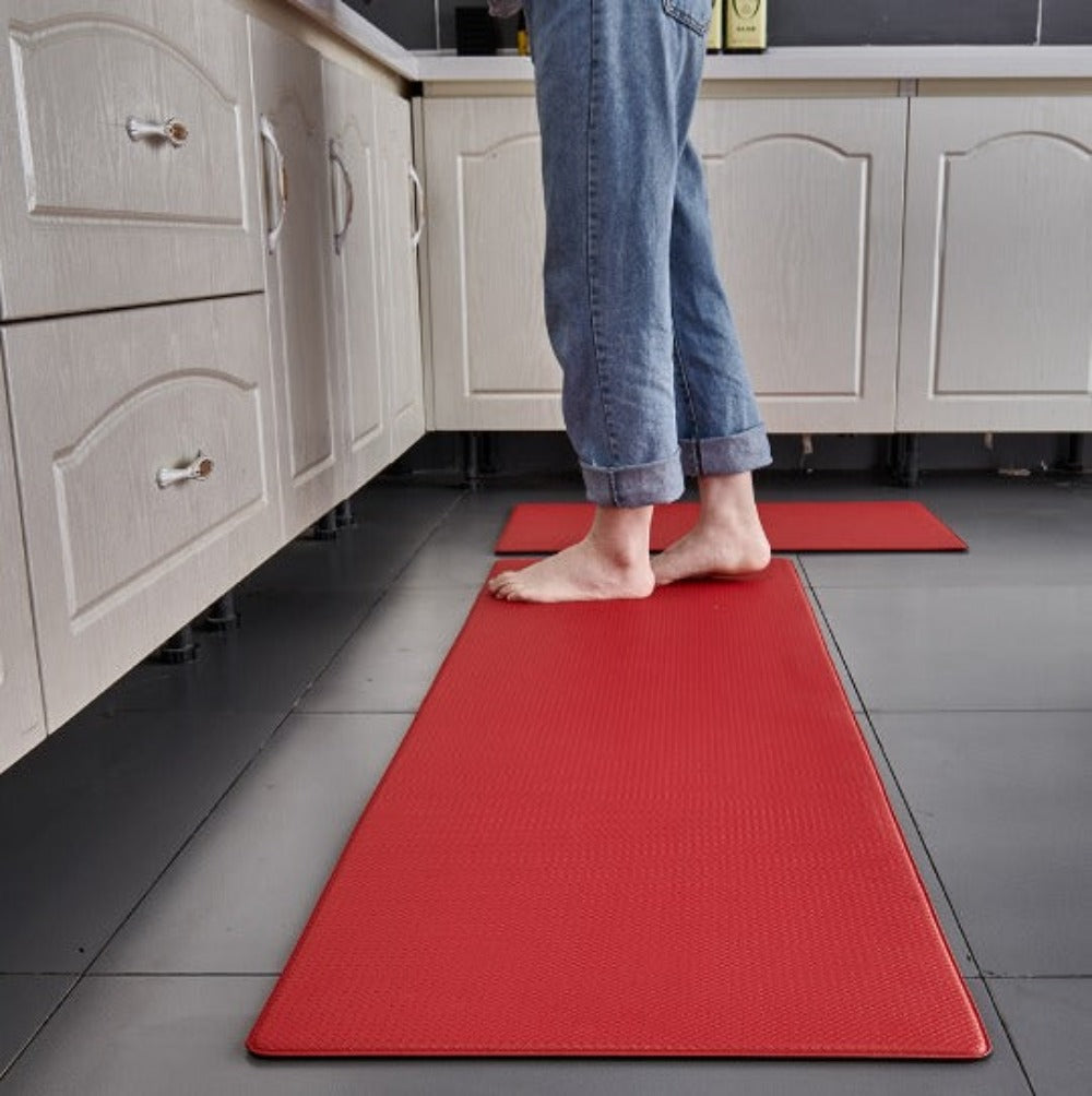 Anti-fatigue kitchen mat in Red in front of kitchen cabinets