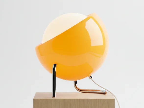 Side view of the amber orange globe table lamp on its chrome tube stand