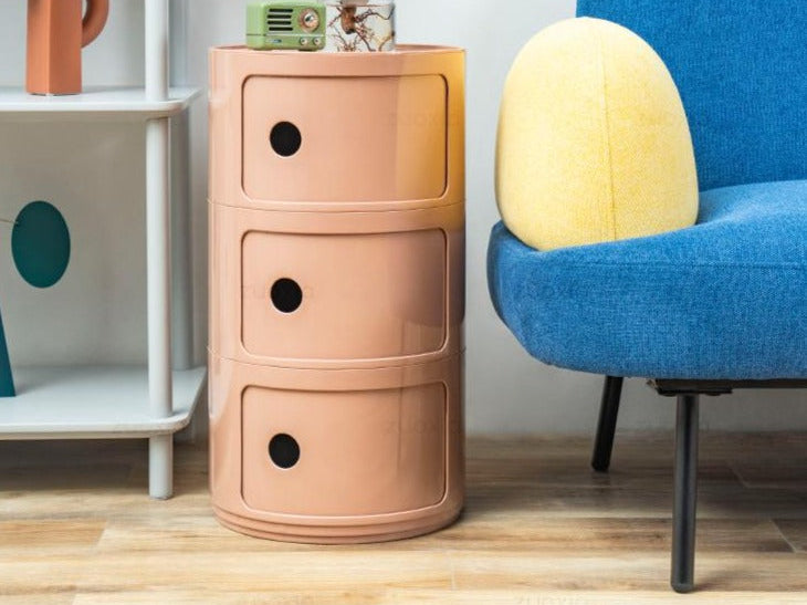 Nude three tier round storage unit beside a blue armchair