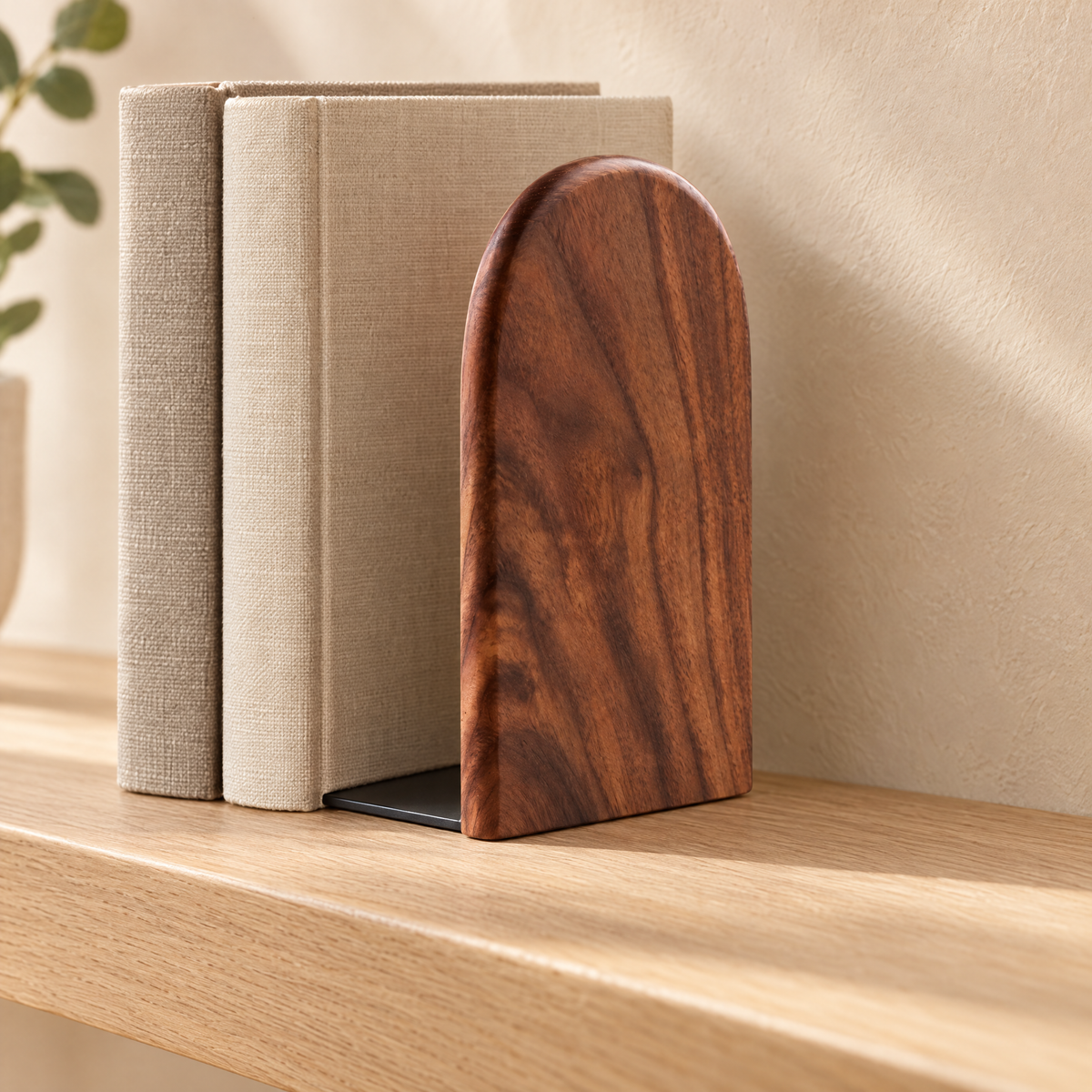 Walnut bookend with its dark metal plate slid under a row of books