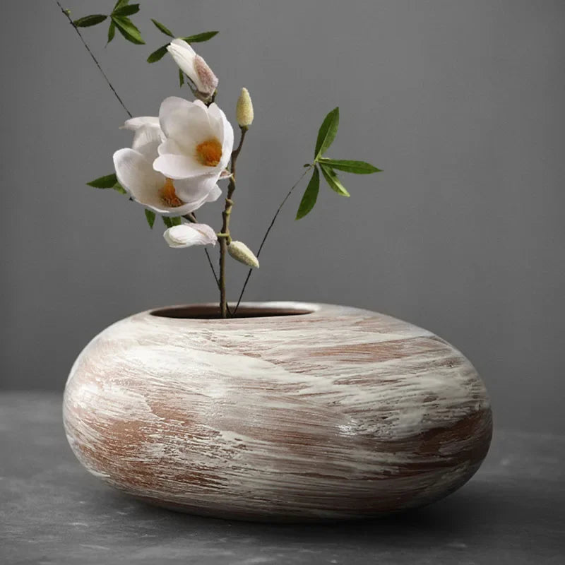 White swirl pebble vase holding a magnolia stem
