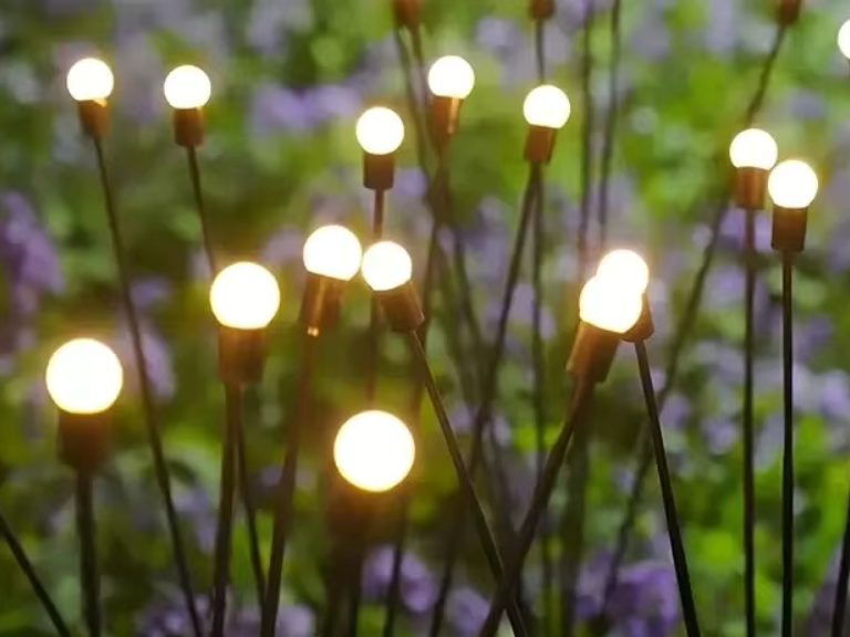 Close view of the round bulbs and black wire stems of the solar firefly garden lights