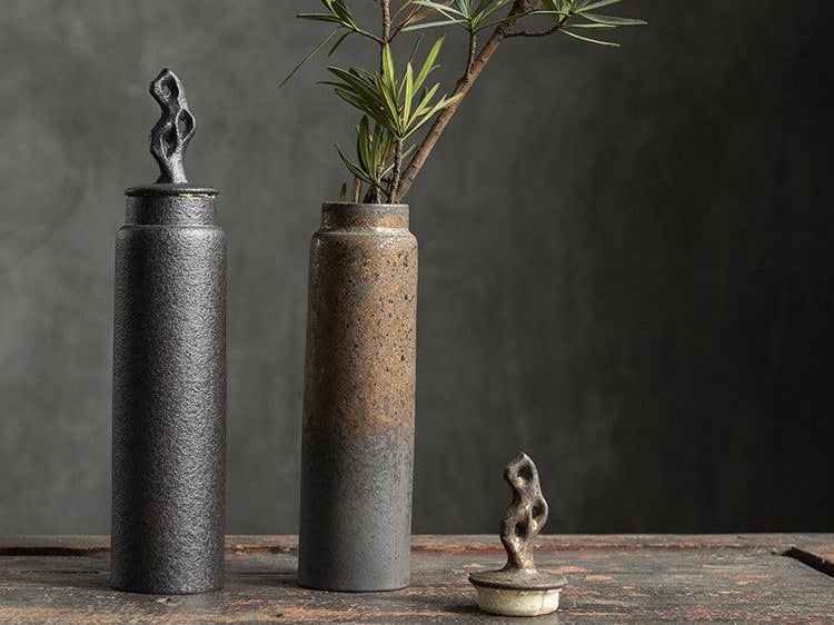 Black and Natural stoneware tea caddies on a dark wood table