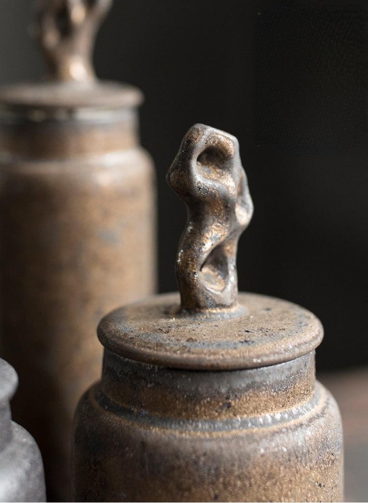 Handmade stoneware tea caddy with airtight ceramic lid side profile against a soft neutral background