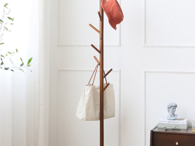 Walnut tree coat rack with a hat and a tote bag in a bright room