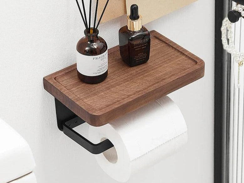 Walnut toilet paper holder with a top ledge holding a diffuser beside a toilet