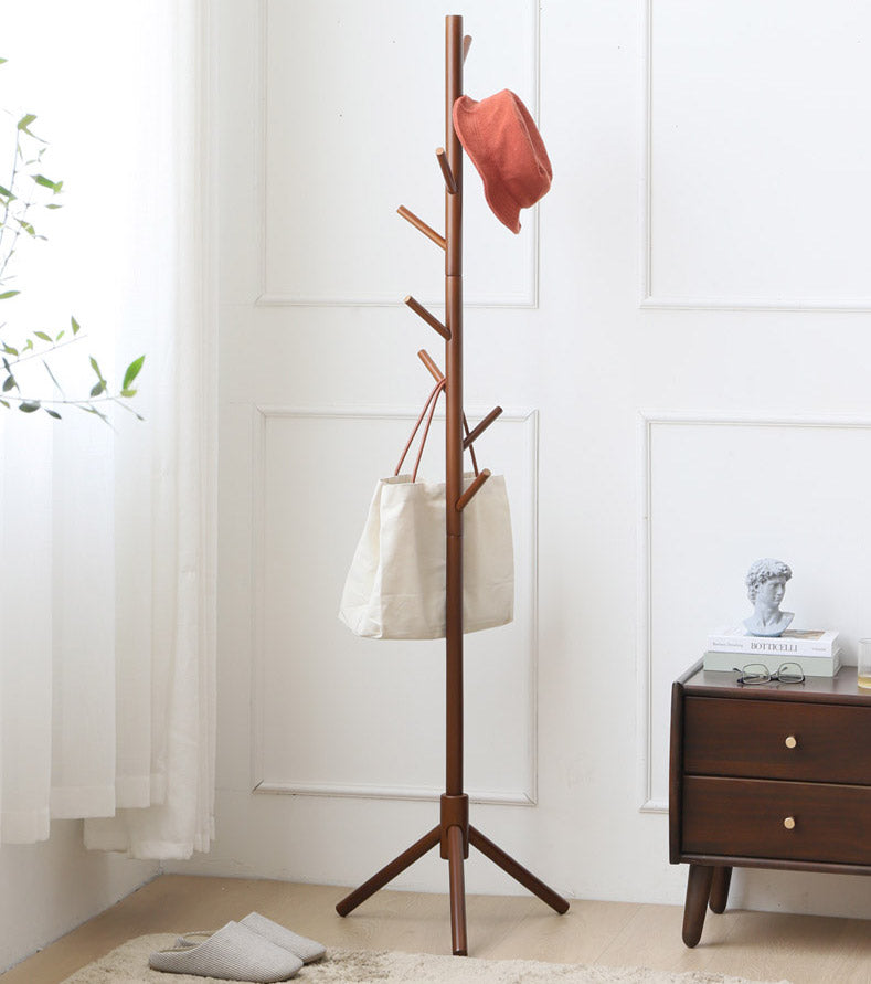 Walnut tree coat rack with a hat and a tote bag next to a nightstand