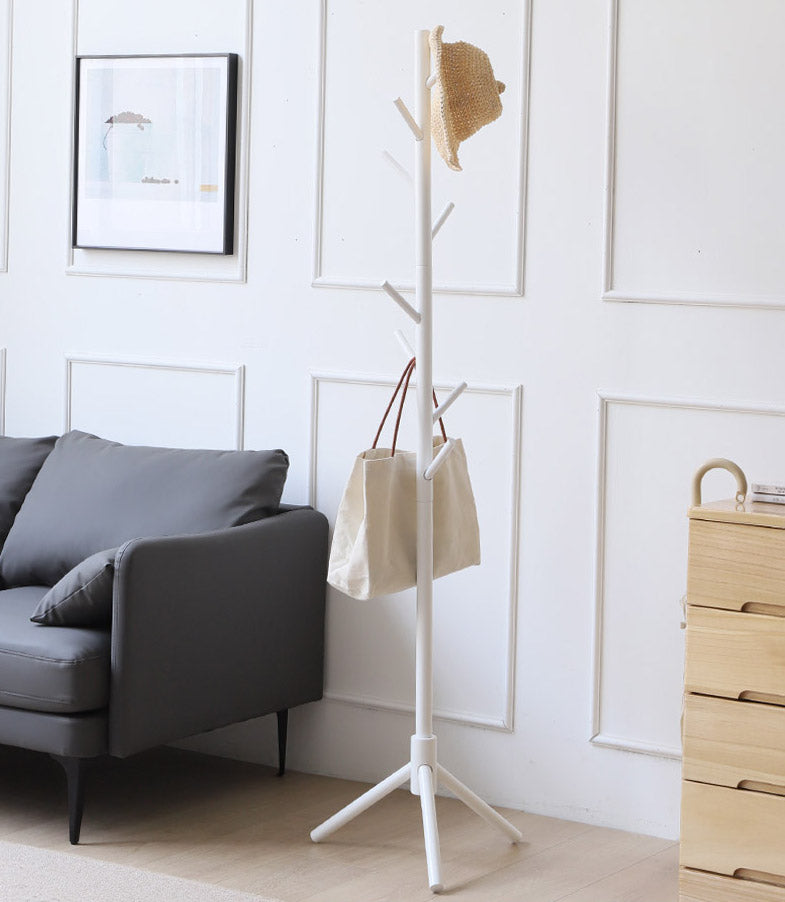 White tree coat rack with a hat and a tote bag in a living room