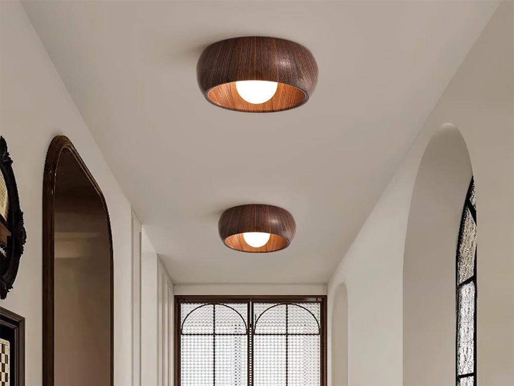 Two walnut wood grain flush mount lights on a hallway ceiling