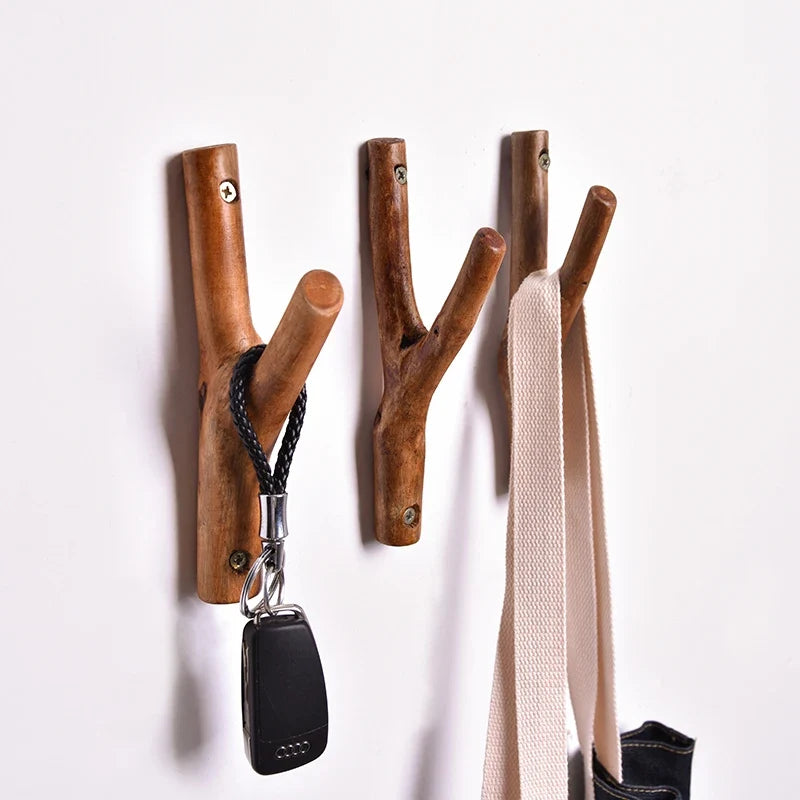 Branch hooks holding a car key and a canvas bag strap